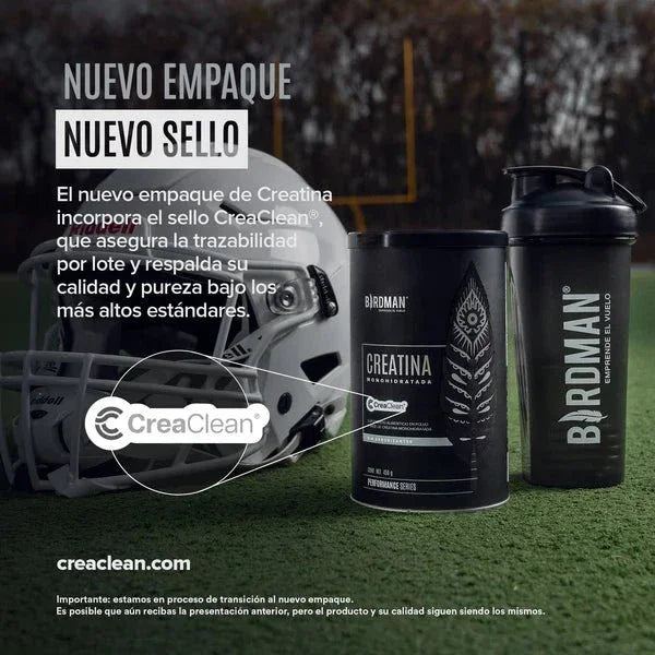 Envase de creatina monohidratada micronizada sin sabor y shaker en campo de fútbol americano.