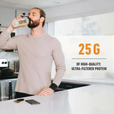Hombre tomando proteína en polvo Isopure Zero Carb sabor vainilla en la cocina, destaca 25g de proteína.